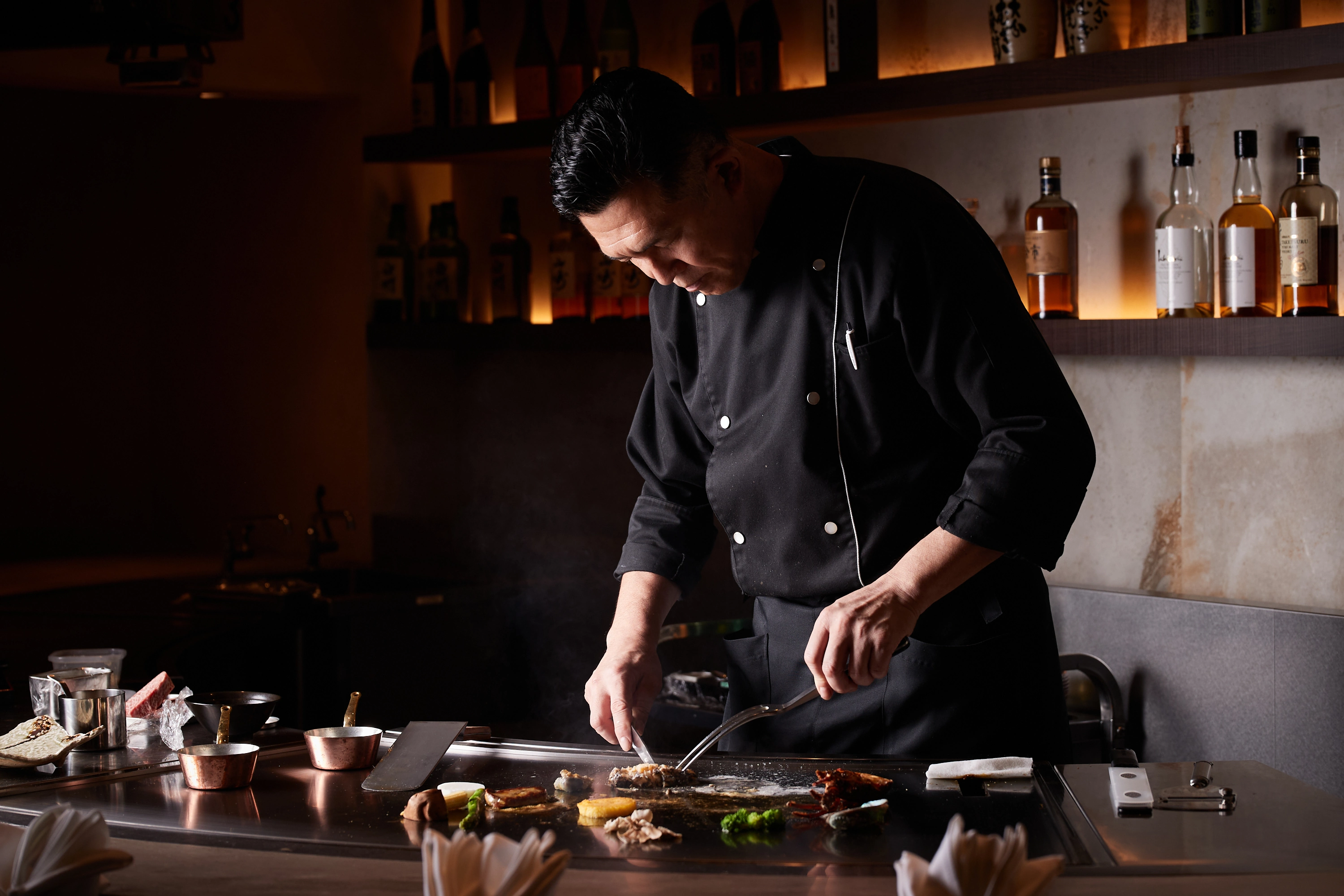 画像：鉄板の上でステーキをカットする様子